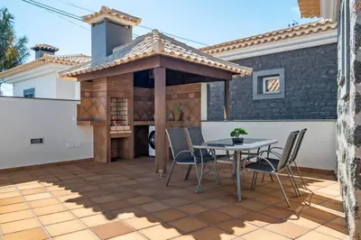 a patio with a table and a gazebo at Casa do Palheiro Ribeirinho by Rent-a-key in Porto Moniz
