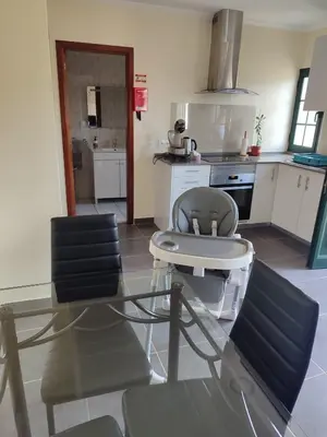 a kitchen with a table and two chairs in it at Quinta' Home in Ribeira da Janela