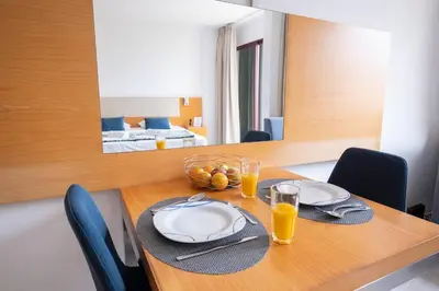 a dining room table with two plates and glasses of orange juice at Sarah's Apartment by GALMI in Caniço
