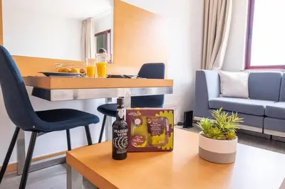 a bottle of beer sitting on a table in a living room at Sarah's Apartment by GALMI in Caniço