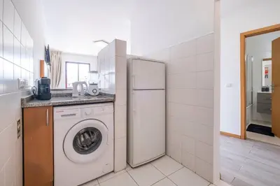 a kitchen with a refrigerator and a washing machine at Sarah's Apartment by GALMI in Caniço