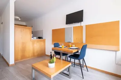a living room with a table and chairs and a television at Sarah's Apartment by GALMI in Caniço