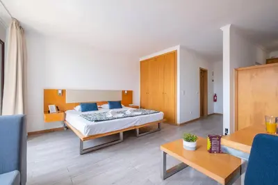 a bedroom with a bed and a living room at Sarah's Apartment by GALMI in Caniço