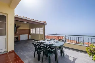 a patio with a table and chairs on a balcony at Villa Sol da Candelária by GALMI in Ribeira Brava
