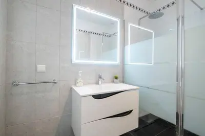a white bathroom with a sink and a shower at Villa Sol da Candelária by GALMI in Ribeira Brava