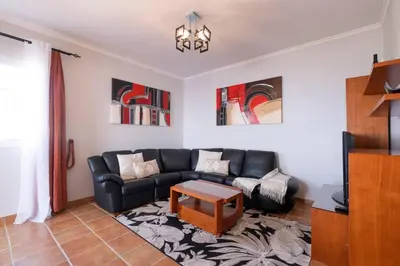 a living room with a black couch and a table at Villa Sol da Candelária by GALMI in Ribeira Brava