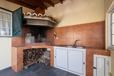 a kitchen with a stove with a fire place at Villa Sol da Candelária by GALMI in Ribeira Brava