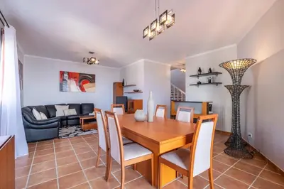 a dining room and living room with a table and chairs at Villa Sol da Candelária by GALMI in Ribeira Brava