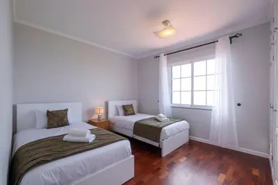 a white room with two beds and a window at Villa Sol da Candelária by GALMI in Ribeira Brava