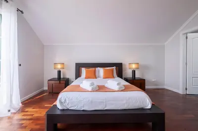 a bedroom with a large bed with orange pillows at Villa Sol da Candelária by GALMI in Ribeira Brava