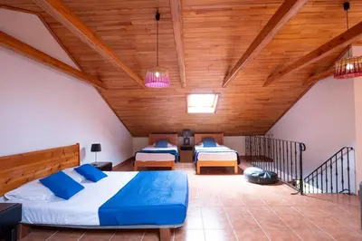 a bedroom with two beds and a wooden ceiling at Casa del Mar I by GALMI in Arco de São Jorge
