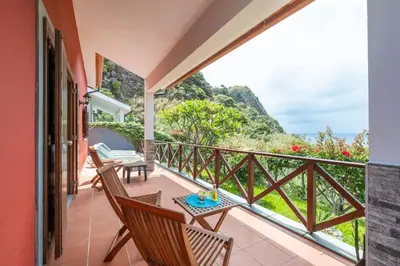 a balcony with chairs and a table with a view at Casa del Mar I by GALMI in Arco de São Jorge