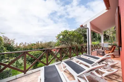 a balcony with two chairs and a table at Casa del Mar I by GALMI in Arco de São Jorge