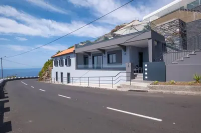 a house on the side of a road next to the ocean at Villa Otto by GALMI in Campanário
