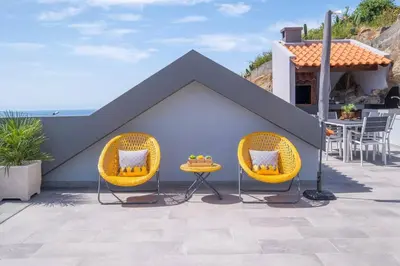 two chairs and a table in the shape of a house at Villa Otto by GALMI in Campanário