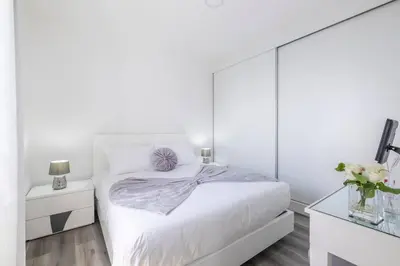 a white bedroom with a bed with a mirrored wall at Villa Otto by GALMI in Campanário