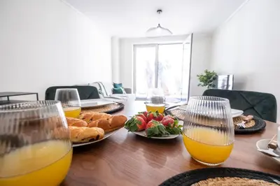 a table with plates of food and glasses of orange juice at Wings Apartment CE by GALMI in Santa Cruz