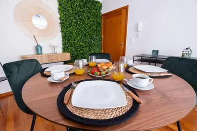 a wooden table with plates and bowls of food on it at Wings Apartment CE by GALMI in Santa Cruz