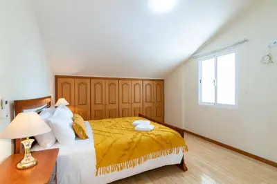 a bedroom with a large bed and a window at Branco's Apartment by GALMI in Ponta do Sol
