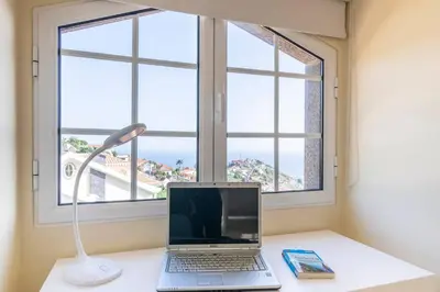 a laptop computer sitting on a desk in front of a window at Branco's Apartment by GALMI in Ponta do Sol
