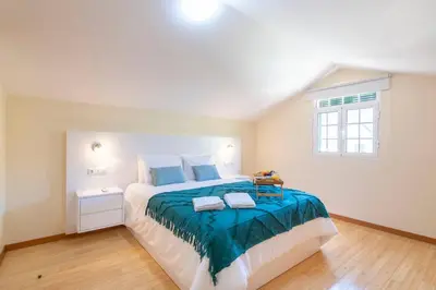 a bedroom with a large bed with a blue blanket at Branco's Apartment by GALMI in Ponta do Sol