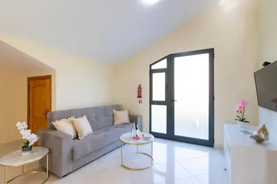 a living room with a couch and a table at Branco's Apartment by GALMI in Ponta do Sol