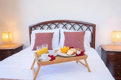 a tray of food on a bed with orange juice at Bernarda's House by GALMI in Ponta do Sol