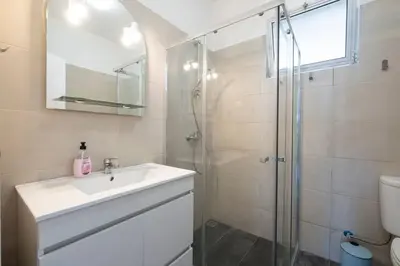 a white bathroom with a sink and a shower at Bernarda's House by GALMI in Ponta do Sol