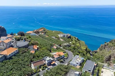 an aerial view of a house on a hill next to the ocean at Bernarda's House by GALMI in Ponta do Sol