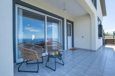 a room with two chairs and a table on a balcony at Bernarda's House by GALMI in Ponta do Sol