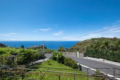 an empty road with the ocean in the background at Bernarda's House by GALMI in Ponta do Sol