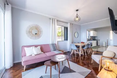 a living room with a pink couch and a table at Bernarda's House by GALMI in Ponta do Sol