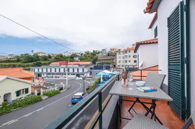 a balcony with a table and a view of a street at Alegria's Apartment by GALMI in Calheta