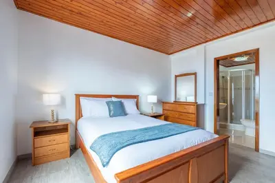 a bedroom with a large bed with a wooden ceiling at Alegria's Apartment by GALMI in Calheta