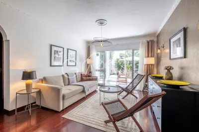 a living room with a couch and a table at Stylish Garden Apartment by GALMI in Caniço