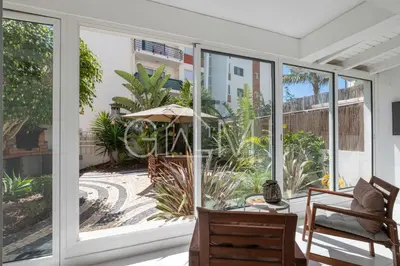a screened in porch with sliding glass doors at Stylish Garden Apartment by GALMI in Caniço