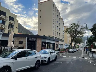 two white cars parked on the side of a street at Sun Beach Apartment in Machico