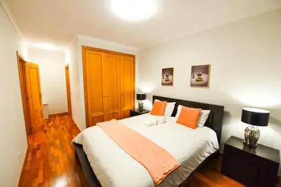 a bedroom with a large white bed with orange pillows at Tranquility Apartment in Caniço