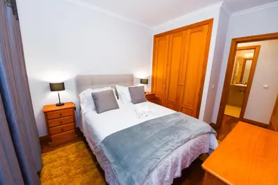 a bedroom with a bed and a lamp on a table at Tranquility Apartment in Caniço