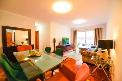 a living room with a table and some chairs at Tranquility Apartment in Caniço
