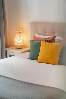 a bed with colorful pillows on top of it at Casa Branca VI by An Island Apart in Funchal