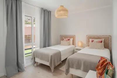 a white room with two beds and a window at Casa Branca VI by An Island Apart in Funchal