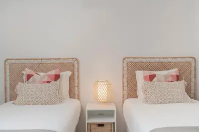 two beds with white and pink pillows in a bedroom at Casa Branca VI by An Island Apart in Funchal