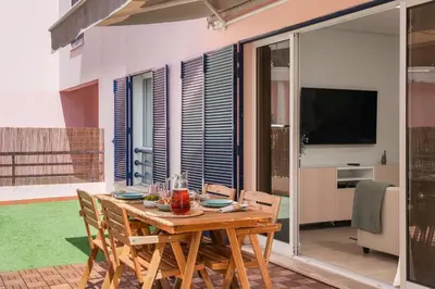 a wooden table and chairs on a patio with a television at Casa Branca VI by An Island Apart in Funchal