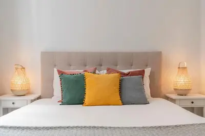 a bedroom with a white bed with colorful pillows at Casa Branca VI by An Island Apart in Funchal