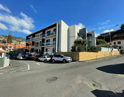 a parking lot with cars parked in front of a building at Funchal Balcony in Funchal