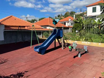 a playground with a slide and a bench on a patio at Funchal Balcony in Funchal