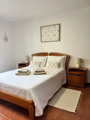 a bedroom with a large bed with white sheets at Seaside & Mountain Views & Cozy Calheta Retreat MQ1 in Calheta