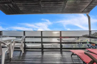 a balcony with a table and chairs and a view of the ocean at Chalé do Areeiro in Funchal
