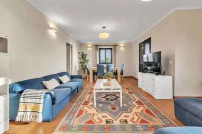 a living room with a blue couch and a tv at Chalé do Areeiro in Funchal